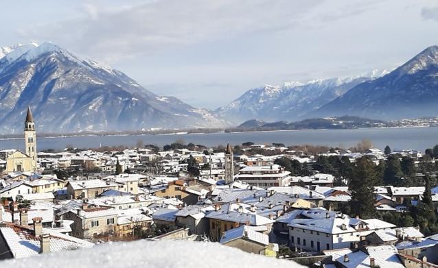 Borgo innevato affacciato su un lago alpino