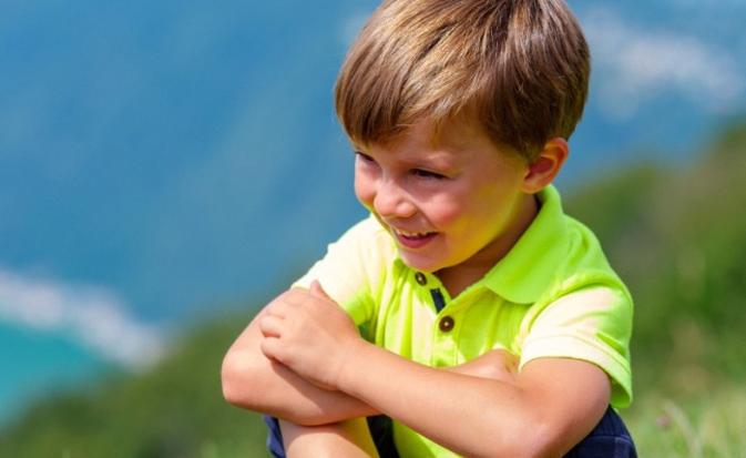 Bambino seduto durante una pausa in montagna